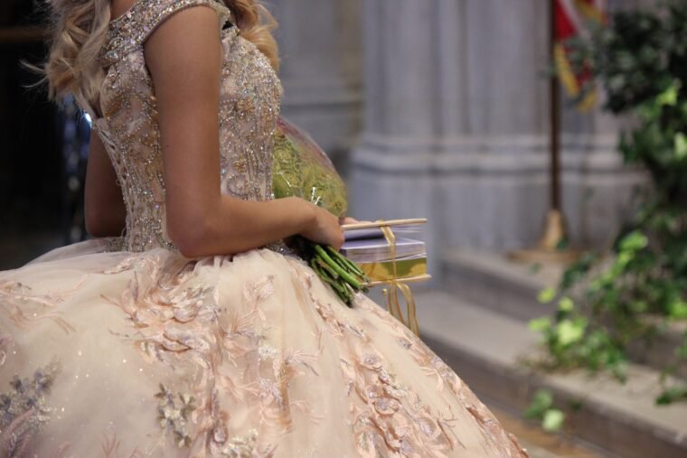 a woman in a ball gown holding a bouquet of flowers